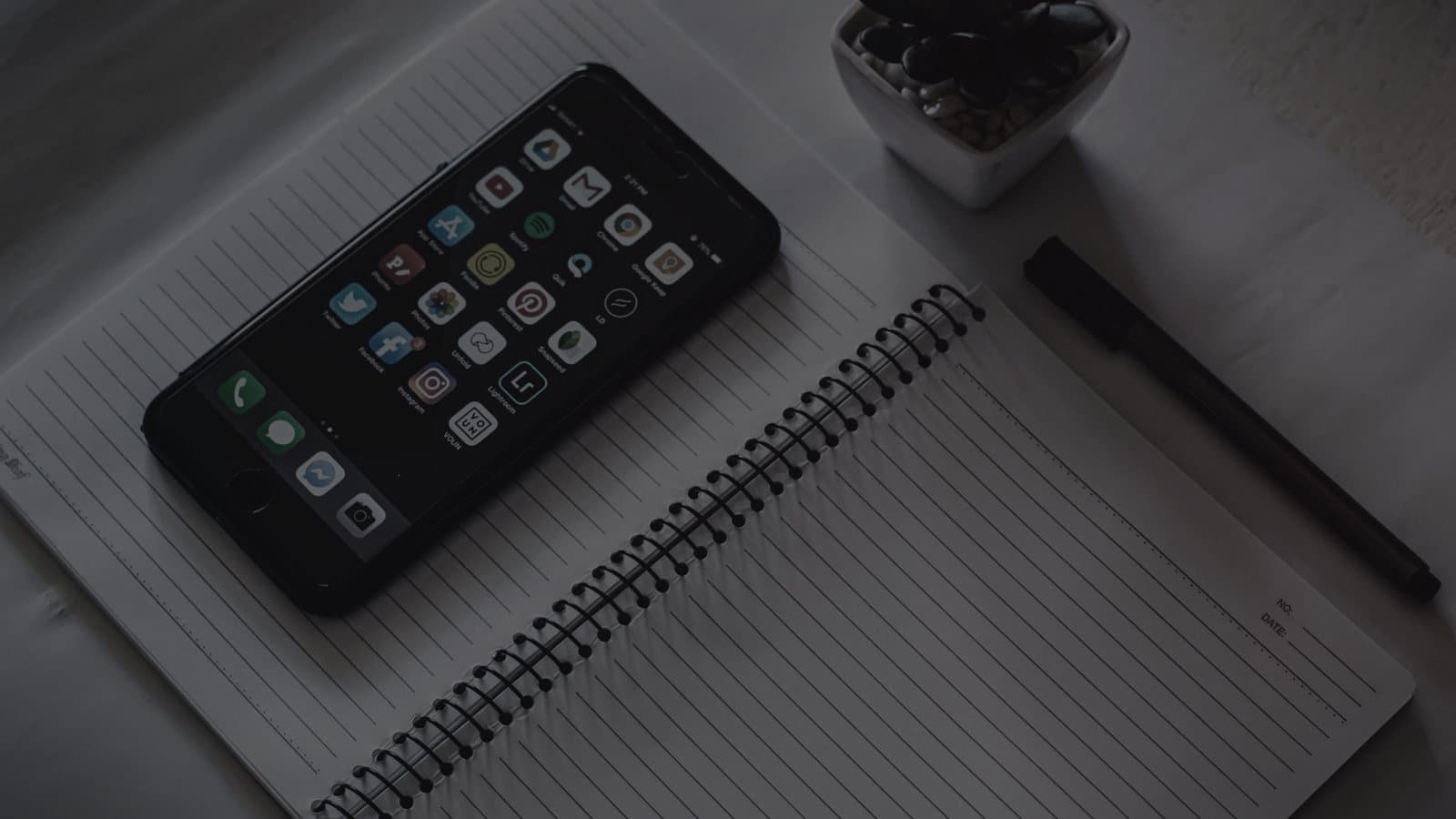 A phone and a notebook on a desk used for planning content
