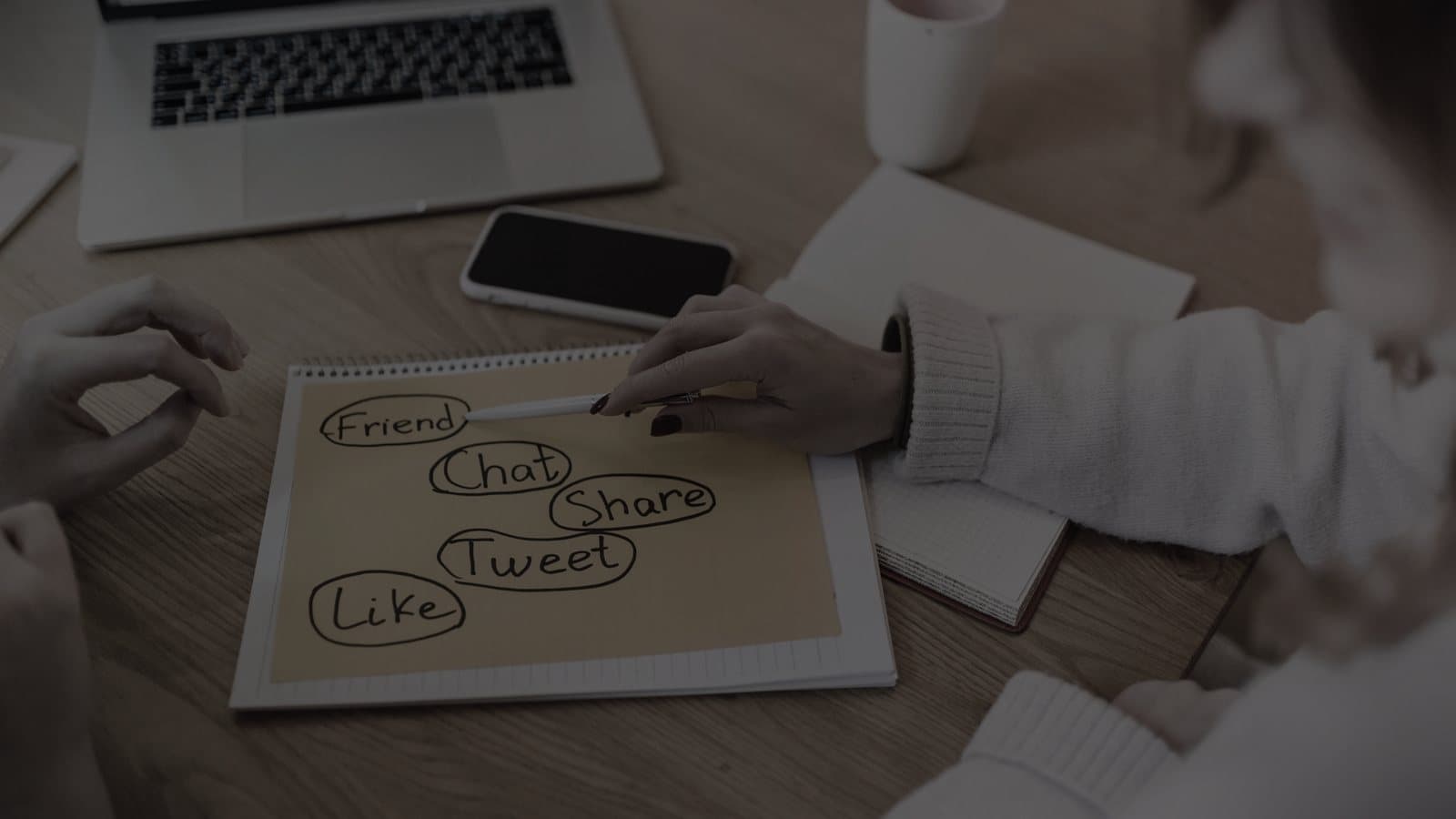 A monthly social media content planner and a smartphone on a desk